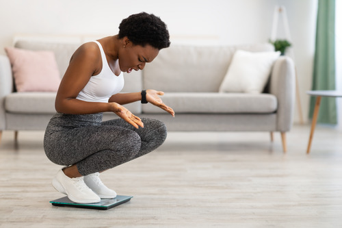 Woman Confused Looking at Scale