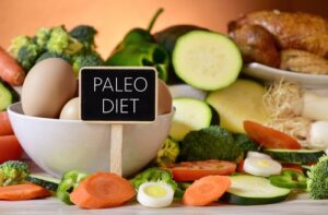 paleo diet signboard with raw vegetables, eggs, and chicken
