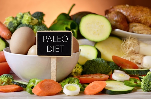 paleo diet signboard with raw vegetables, eggs, and chicken